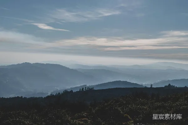 高清摄影 白天天边白云间绿树与山峦
