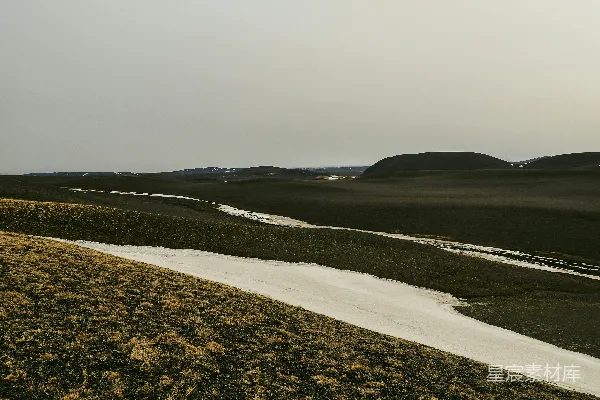 高清摄影 一片长满草的平原，一条小溪流经其中