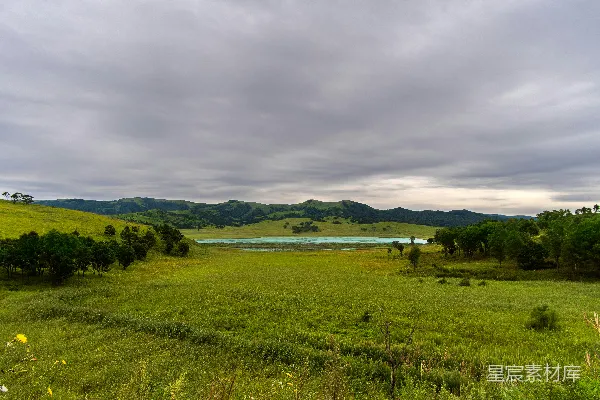 高清摄影 绿草.fields 距离 湖边 在 阴云密布 的 天空中 白天