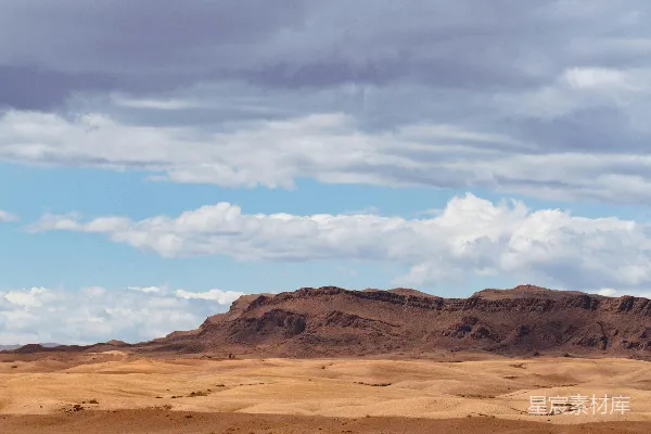 高清摄影 沙漠中一座山峦在阴云密布的天空下