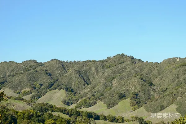 高清摄影 起伏的绿 hills 在蓝天白云下