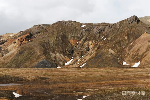 高清摄影 崎岖的山地景观，有山脉、雪地和阴云天空。