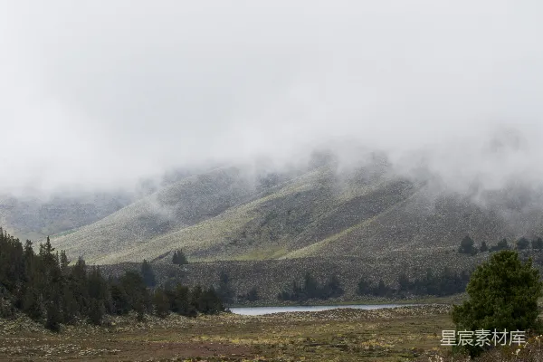 高清摄影 山间雾气缭绕的风景，前景有一湖清水。