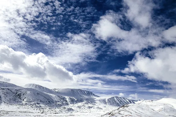 高清摄影 白天雪山覆盖白雪，白云蓝天映衬之下