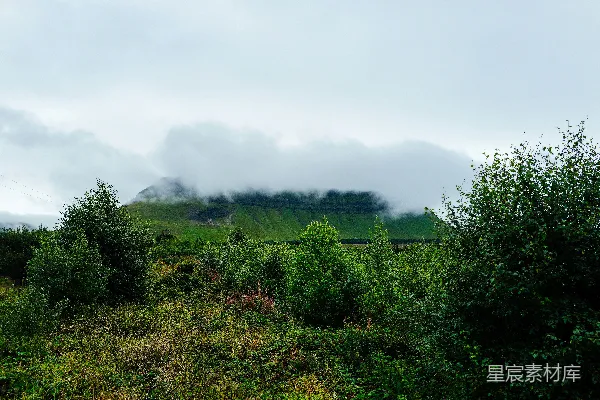高清摄影 蒙蒙云雾遮蔽着一片绿色的山景。