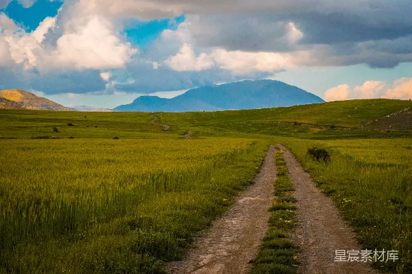 高清摄影 一片草地通向云雾缭绕中的山峦。