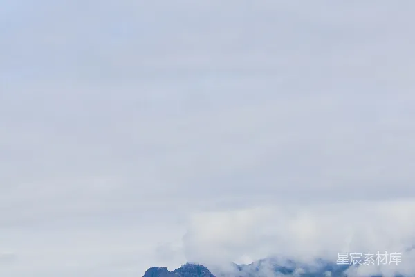 高清摄影 白天雪花覆盖的山峦下云层缭绕