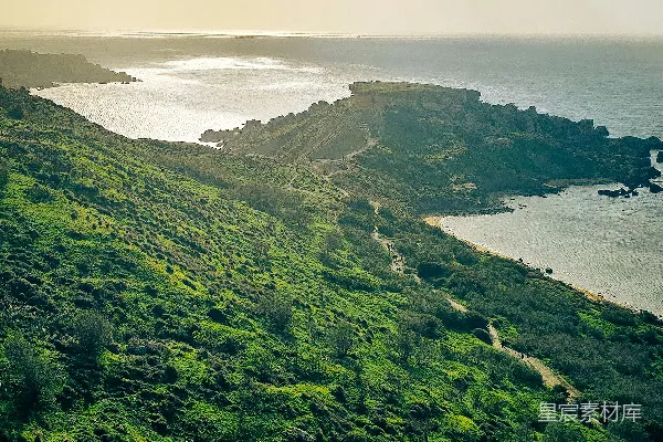 高清摄影 绿色的山峦俯瞰着一片海湾，在阴云密布的天空下。
