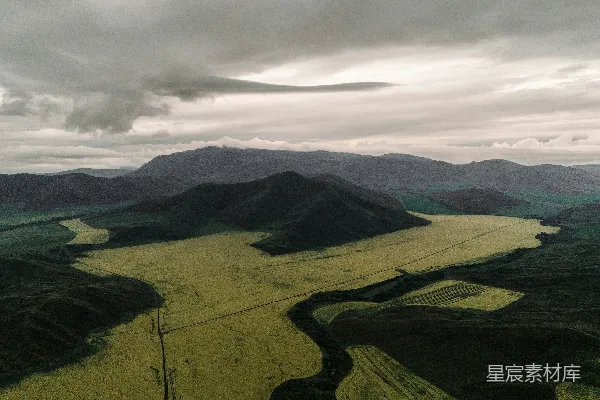 高清摄影 连绵的山峦下是黄田，在一片阴云的天空之下。