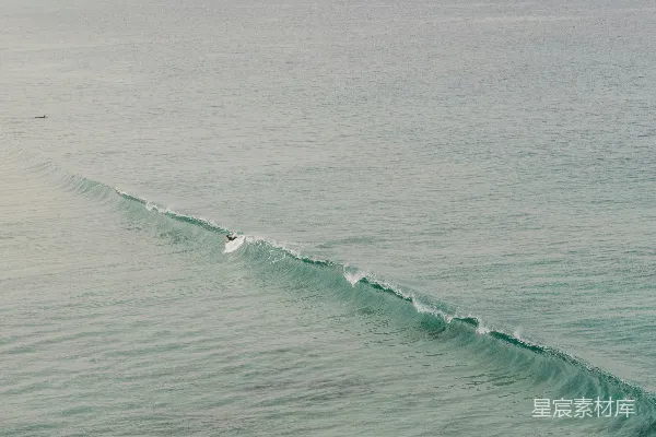 高清摄影 海洋中一名人在冲浪板上滑行的场景