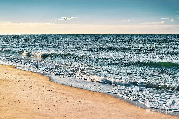高清摄影 一片沙白的海滩，海浪涌向岸边。