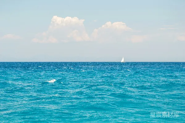 高清摄影 白天白色小船在蓝色海面上方，白云下面是白色的云朵