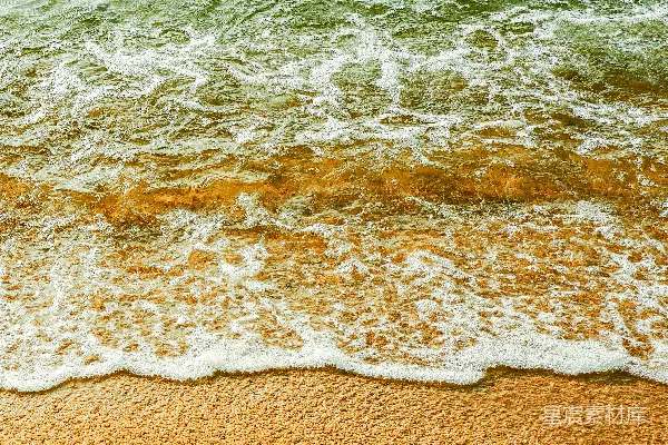 高清摄影 一片细软的沙滩，海水涌向岸边。