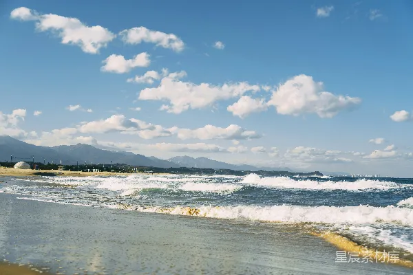 高清摄影 一片沙滩，海水时进时出涌动着波浪。