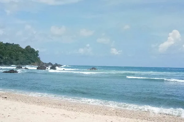 高清摄影 一片沙子覆盖的海滩，波浪涌向岸边。
