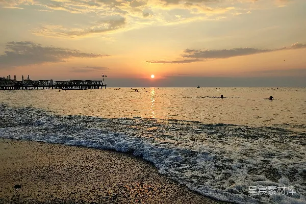 高清摄影 海边的日落，人们在水中游泳