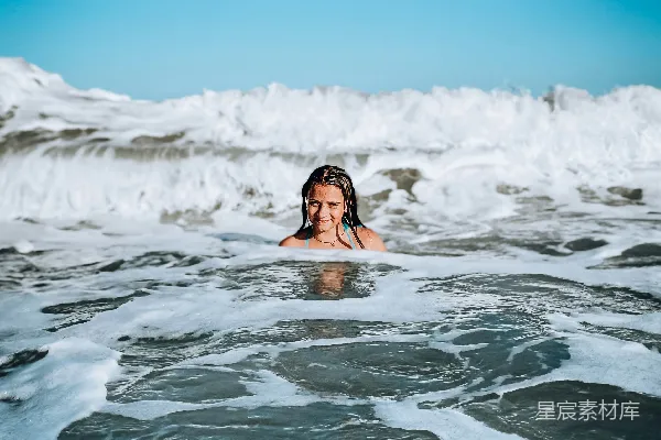 高清摄影 一个女人正在海中游泳，她的头露出水面。