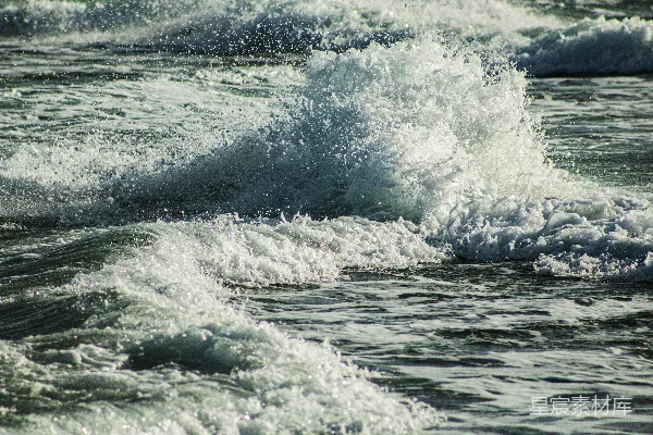 高清摄影 海边一个骑着冲浪板的人在波浪上。
