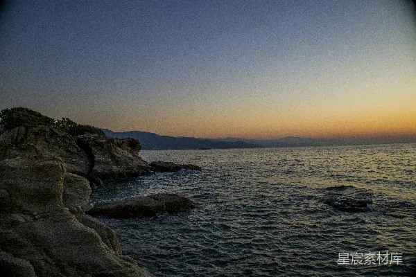 高清摄影 夕阳西下，海天相接处有一块岩石突兀。
