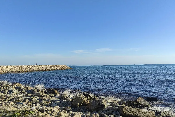 高清摄影 岩石嶙峋的海边，背景中有水面。
