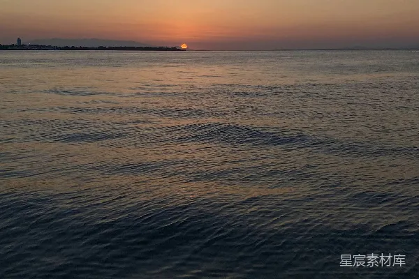高清摄影 夕阳西下，海天相连处有一叶小舟。