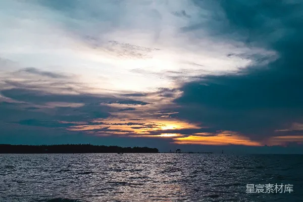 高清摄影 夕阳下波光粼粼的海浪在阴云密布的天空中