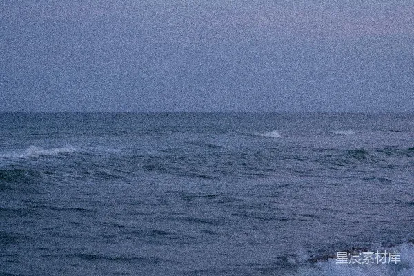高清摄影 一个骑着冲浪板的人在波涛汹涌的海滩上滑行。