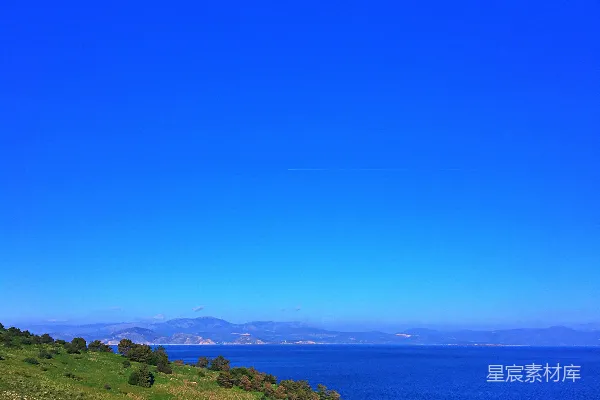 高清摄影 一段木椅坐在山坡一侧，俯瞰一片水域。