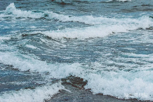 高清摄影 海边上一个骑在冲浪板上的身影在波浪上