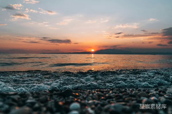 高清摄影 海滩上的太阳正落下海面。