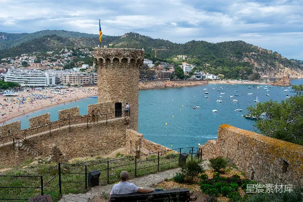 高清摄影 一个男人坐在长凳上望着水边。