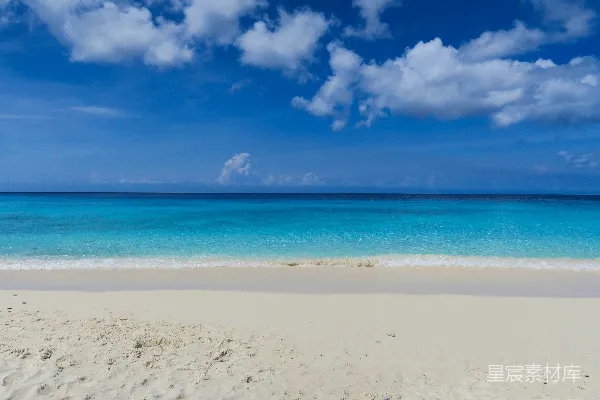 高清摄影 一片沙白的海滩，蓝色的海水和云朵。