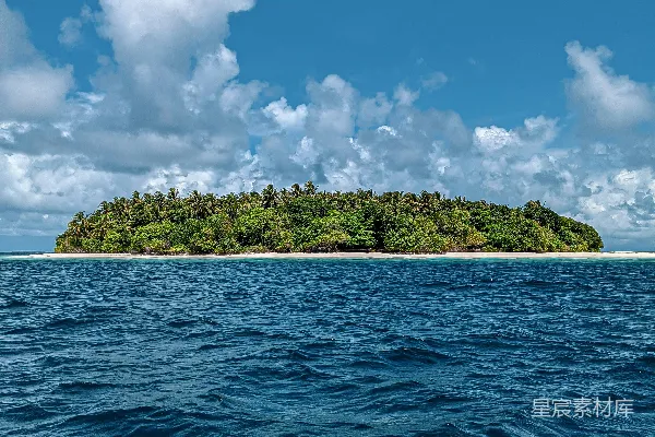 高清摄影 绿色小岛周围是蓝色的海水，在白云蓝天的背景下白天景色。