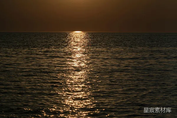 高清摄影 背景中有一片广阔的水域，夕阳西下。