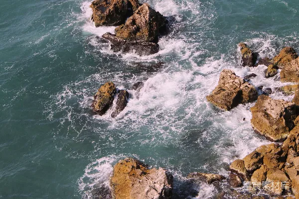 高清摄影 岩石嶙峋的海边，背景是水面。