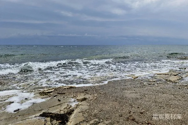 高清摄影 一片岩石嶙峋的海滩，海浪拍打着岸边。