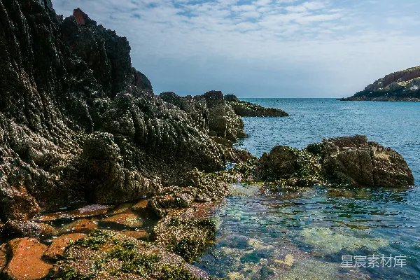 高清摄影 一片岩石嶙峋的海滩，在其背景中有一片水面。