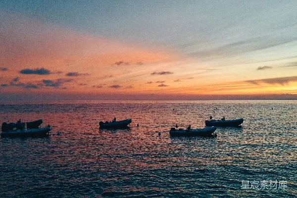 高清摄影 四艘船在日落时漂浮在海洋上。