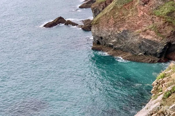 高清摄影 一座悬崖旁边有一大片水域。