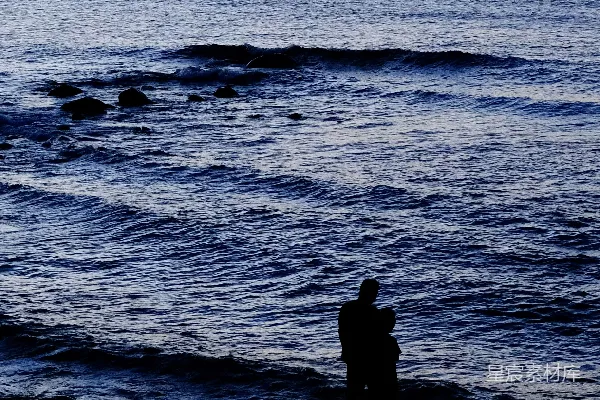 高清摄影 海滩上站着一个男人，旁边是海洋。