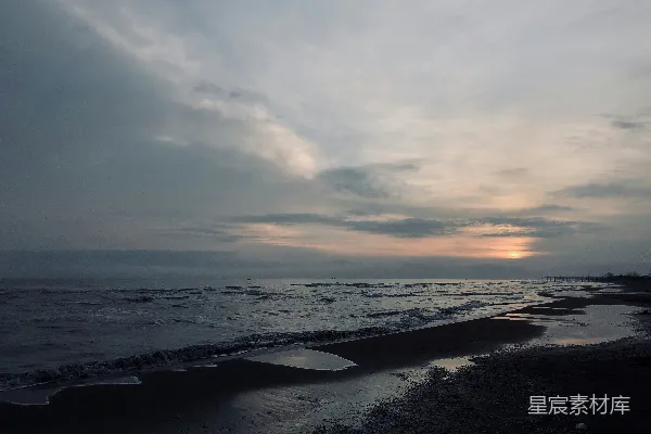 高清摄影 一天中的太阳在云层的背景下正落下海面。