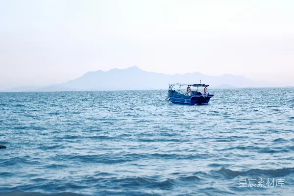 高清摄影 一艘小蓝船漂浮在一大片水体上。