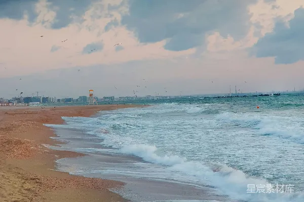 高清摄影 一片沙白的海滩，波浪涌向岸边。