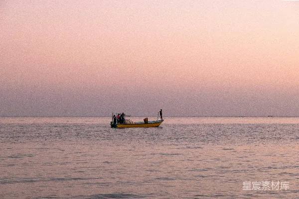 高清摄影 夕阳下，一只船行驶在平静的海面上。