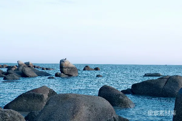 高清摄影 海滩上站立着一个人，旁边是一片水域。
