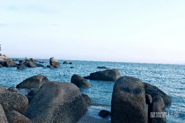 高清摄影 岩石嶙峋的海滩，水中有大石头。