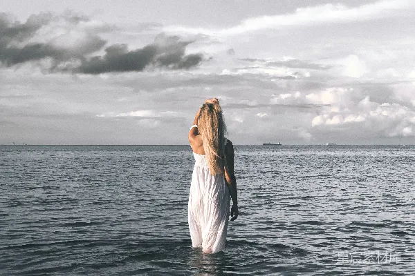 高清摄影 一个女人站在水边仰望天空。