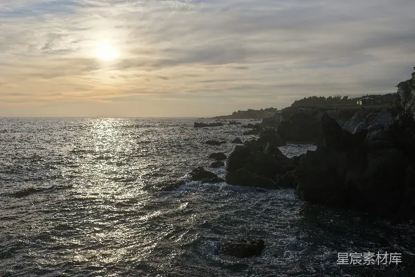 高清摄影 夕阳映照在一块岩石海岸和海洋上。