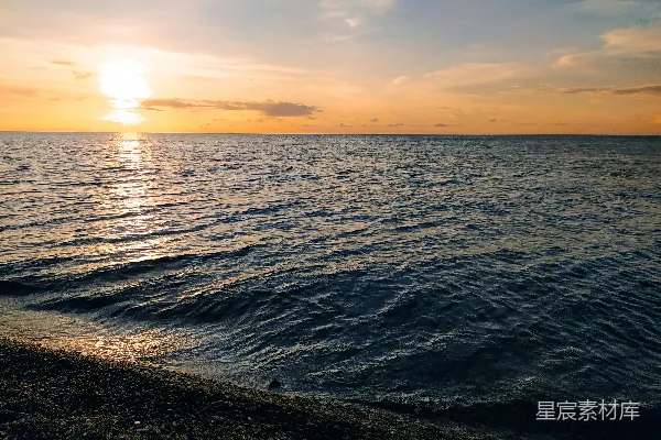 高清摄影 海滩上的水面正落下夕阳的余晖。