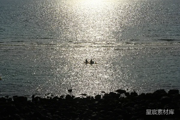 高清摄影 阳光在水面上闪烁，有两名桨手。